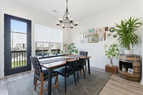 a dining room with furniture a chandelier and wooden floor