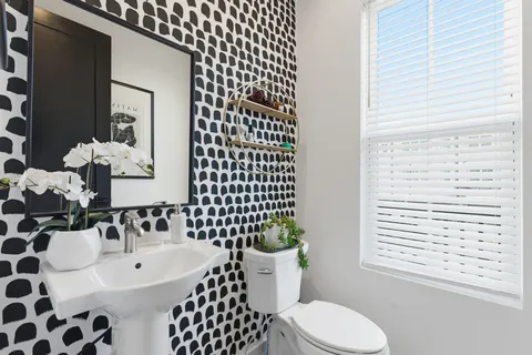 a bathroom with a sink a toilet a mirror and shower curtain