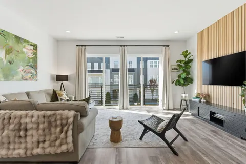 a living room with furniture a flat screen tv and a large window