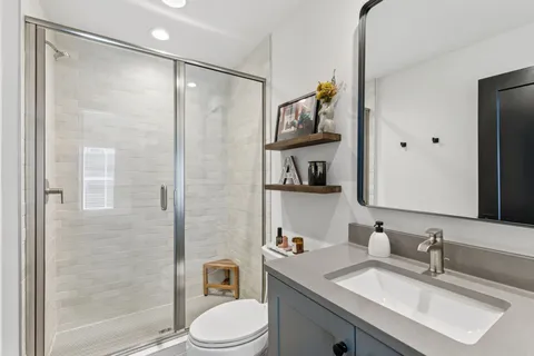 a bathroom with a sink toilet a mirror and shower