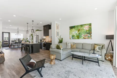 a living room with furniture and a view of kitchen