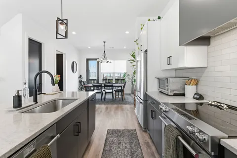 a kitchen with sink a stove and chairs