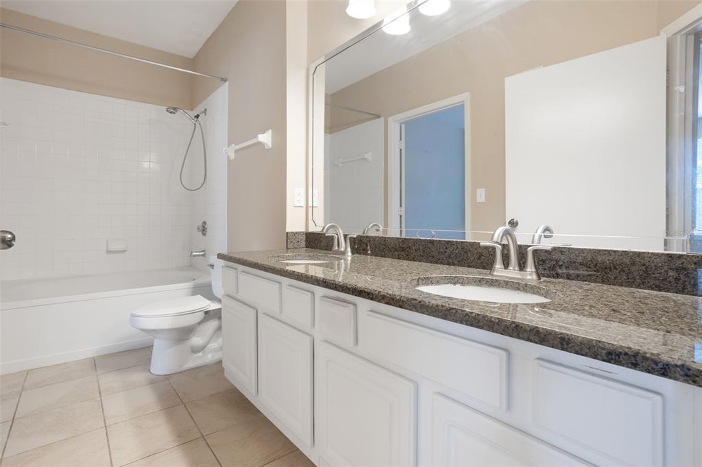 408 Summit Ridge Place, Unit 210 Longwood, FL 32779 - Photo 16 of 32 a bathroom with a granite countertop sink a toilet and bathtub