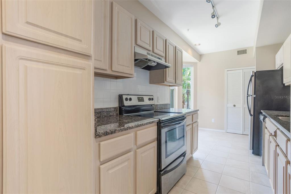 408 Summit Ridge Place, Unit 210 Longwood, FL 32779 - Photo 8 of 32 a kitchen with stainless steel appliances granite countertop a stove a refrigerator and a sink