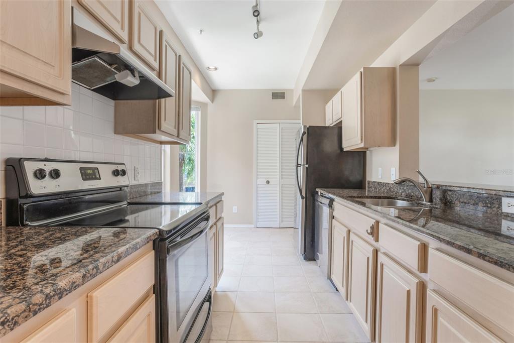 408 Summit Ridge Place, Unit 210 Longwood, FL 32779 - Photo 9 of 32 a kitchen with stainless steel appliances granite countertop a sink stove and refrigerator