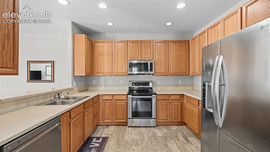 4023 Diamond Ridge View Colorado Springs, CO 80918 - Photo 11 of 31 a kitchen with a sink a refrigerator a microwave a stove and cabinets