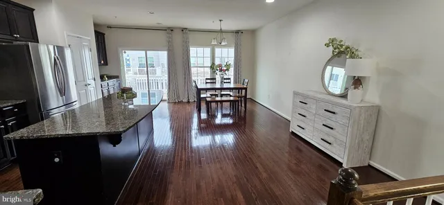 a dining room with furniture a chandelier and wooden floor
