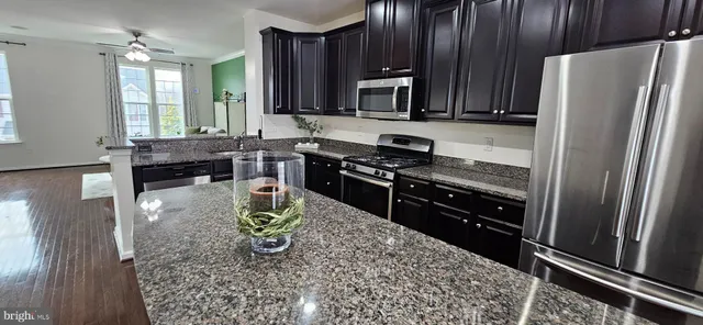 a kitchen with stainless steel appliances granite countertop a refrigerator stove and sink