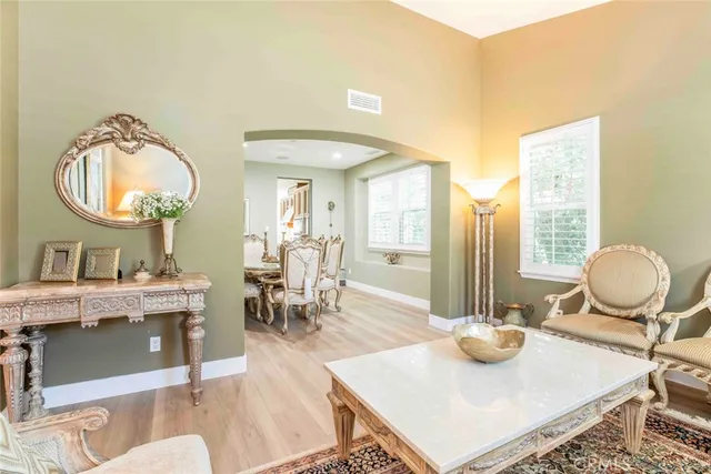 a living room with furniture kitchen view and a potted plant