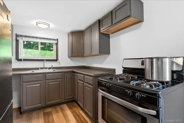 a kitchen with stainless steel appliances a stove a sink and cabinets