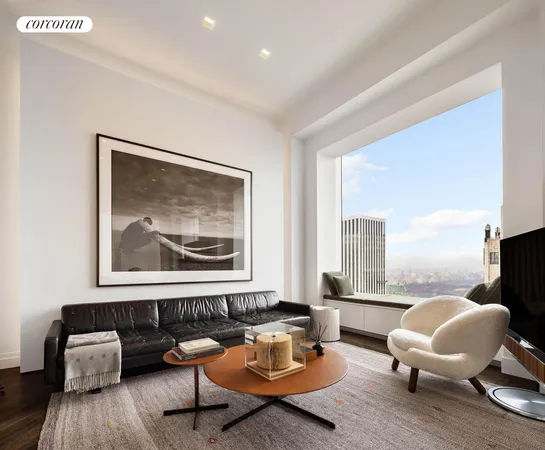 a living room with furniture a flat screen tv and a refrigerator