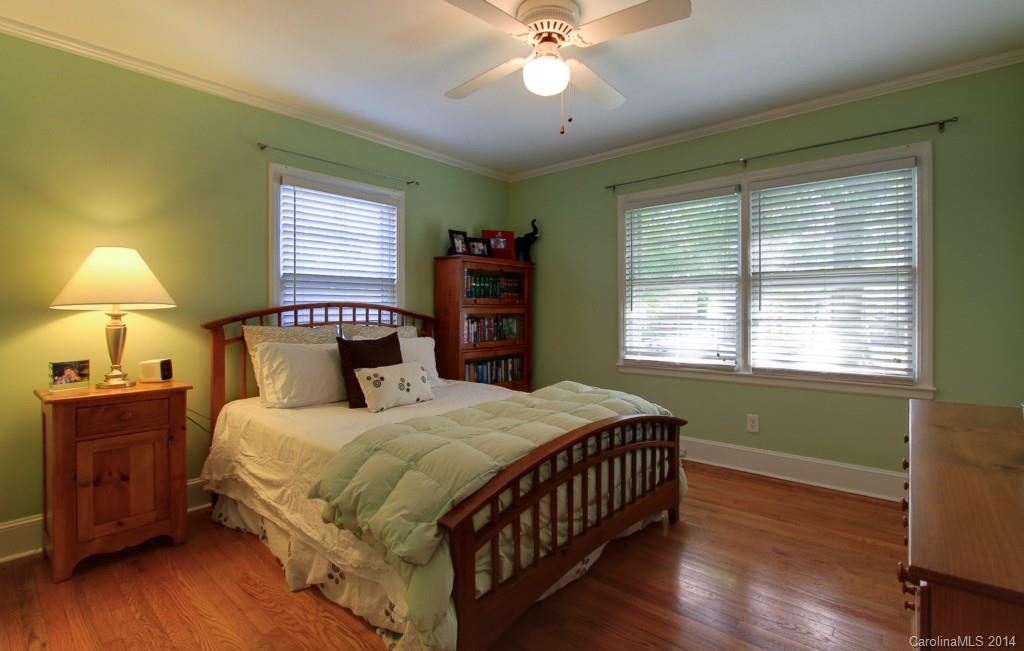 4310 Walker Road Charlotte, NC 28211 - Photo 11 of 16 a bedroom with a bed and a chandelier