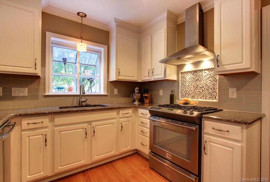 4310 Walker Road Charlotte, NC 28211 - Photo 5 of 16 a kitchen with granite countertop white cabinets and a stove