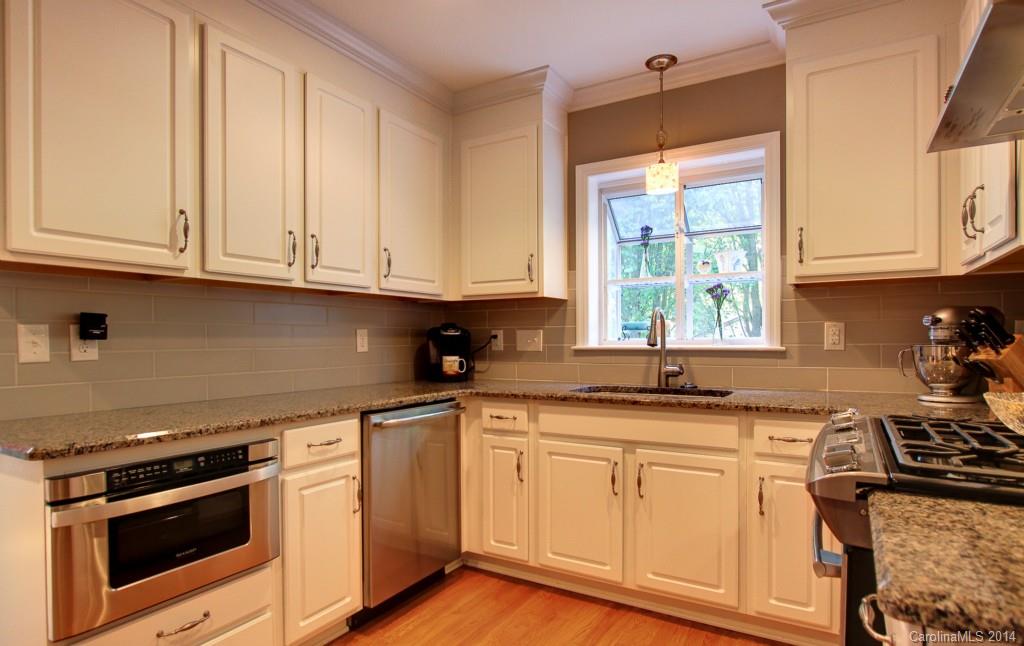 4310 Walker Road Charlotte, NC 28211 - Photo 7 of 16 a kitchen with granite countertop white cabinets and a stove top oven