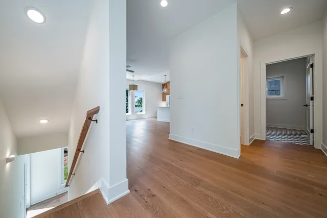 a view of a hallway with wooden floor and stairs