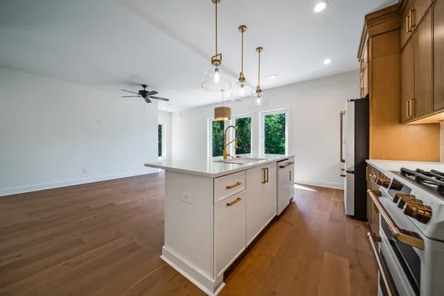 a kitchen with stainless steel appliances kitchen island wooden floors cabinets and a counter top space