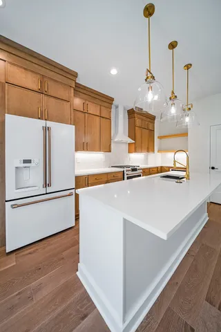 a kitchen with kitchen island a stove a sink and a refrigerator