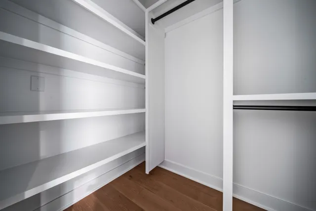 a view of walk in closet with empty racks