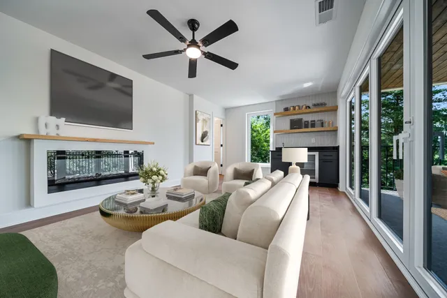 a living room with furniture a flat screen tv and a fireplace