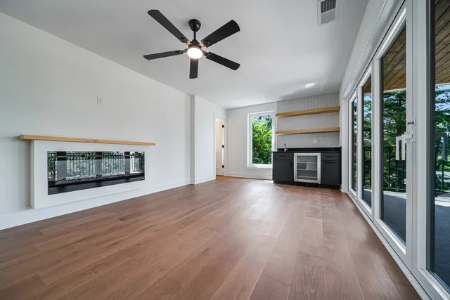 an empty room with wooden floor a fireplace and a window