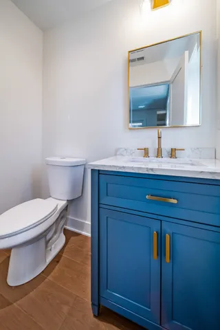 a bathroom with a toilet a sink and mirror
