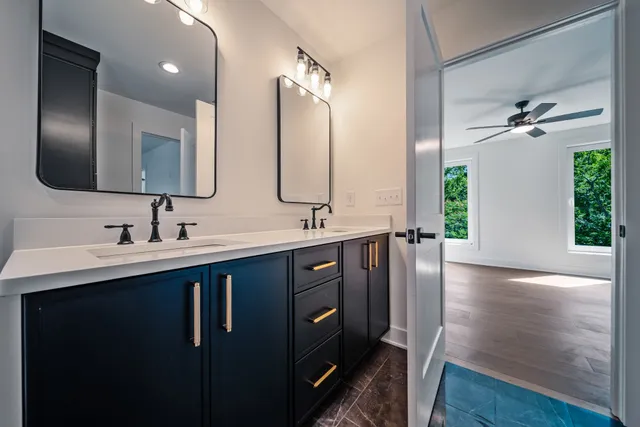 an empty room with wooden floor chandelier fan and windows
