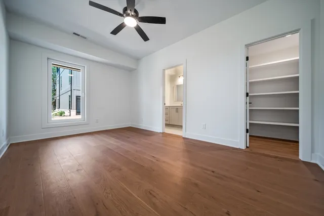 a view of empty room with wooden floor and window