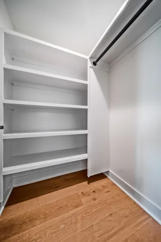 a view of walk in closet with empty racks