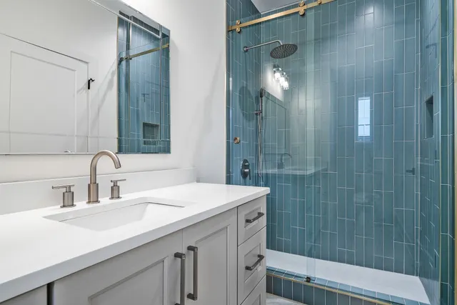 a bathroom with a sink shower and a mirror
