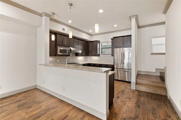 a kitchen with stainless steel appliances granite countertop a refrigerator and a stove top oven