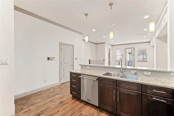 a kitchen with a sink cabinets and wooden floor