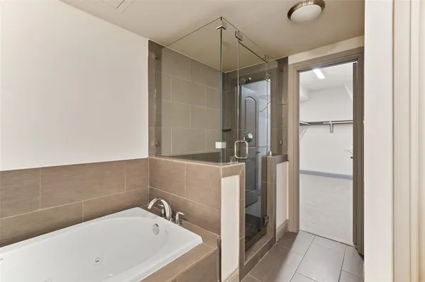 a bathroom with a tub a sink and mirror