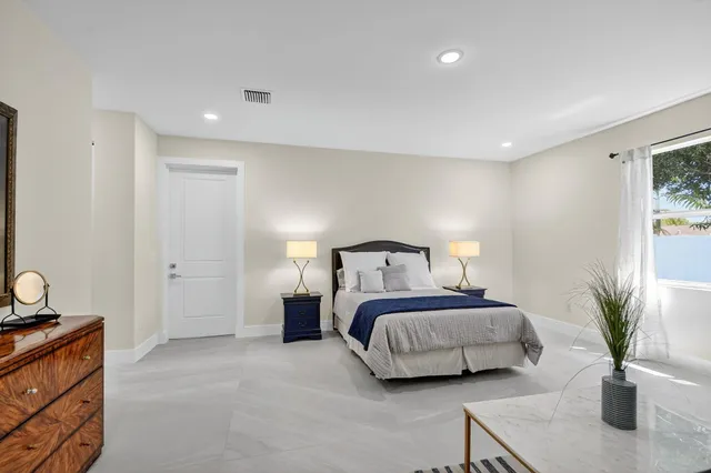 a bedroom with a bed and large windows