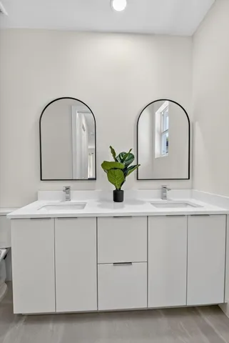 a backyard of a house with plants and large tree