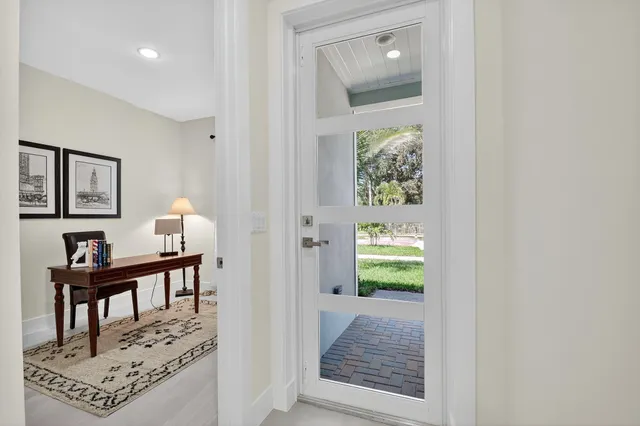 a kitchen with stainless steel appliances granite countertop a table chairs refrigerator and sink