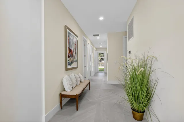 a kitchen with stainless steel appliances granite countertop a dining table chairs refrigerator and cabinets