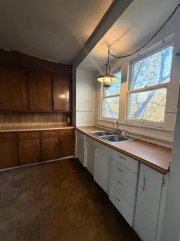 a kitchen with stainless steel appliances granite countertop a sink a stove and a window
