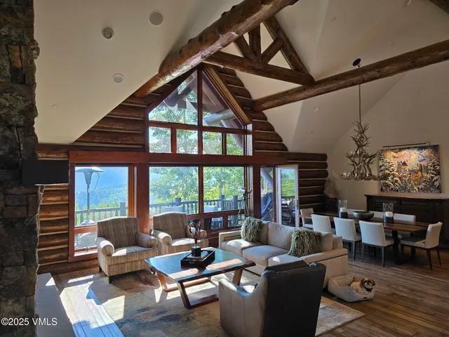 a living room with furniture a fireplace and large windows
