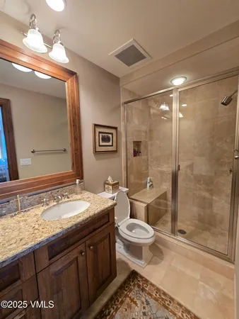 a bathroom with a double vanity sink toilet and shower