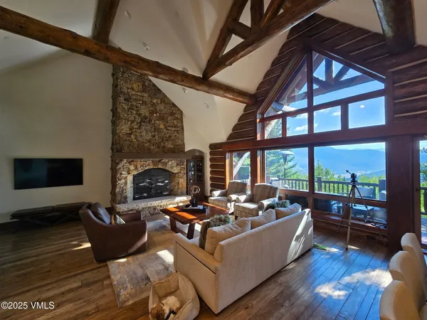 a living room with furniture a fireplace and a floor to ceiling window