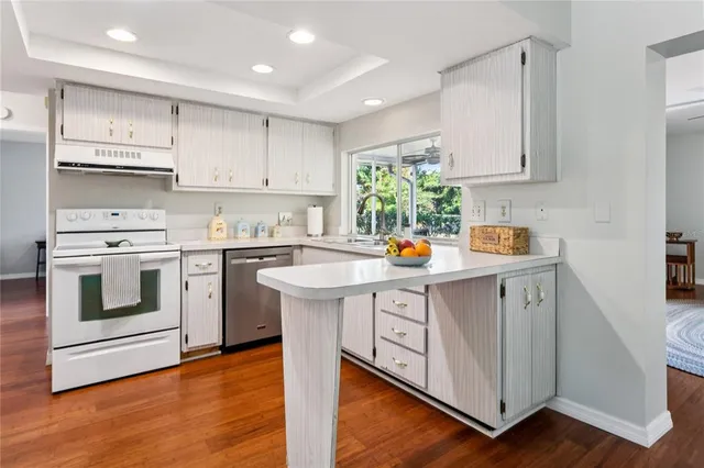 a kitchen with stainless steel appliances granite countertop a refrigerator a stove and a sink