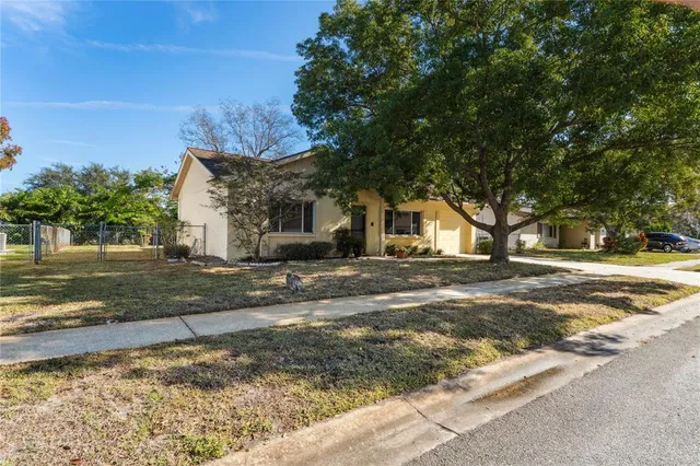 a view of a house with backyard and bushes