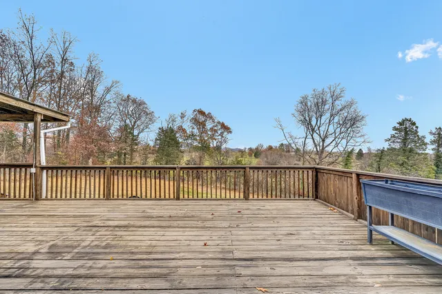 a view of roof deck with wooden floor and fence