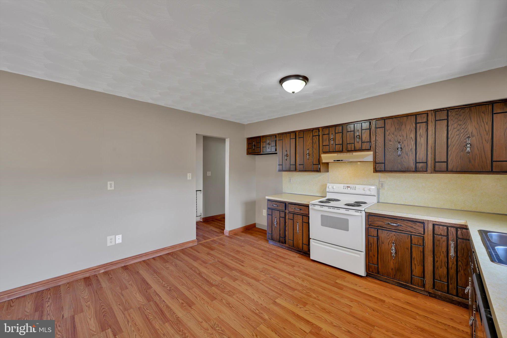 301 West Walnut Street Valley View, PA 17983 - Photo 16 of 40 a kitchen with stainless steel appliances granite countertop a stove a sink dishwasher and a refrigerator with wooden floor