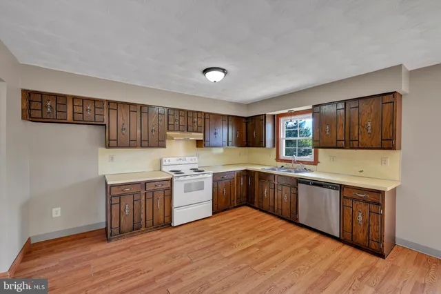 a large kitchen with stainless steel appliances granite countertop a stove and a sink