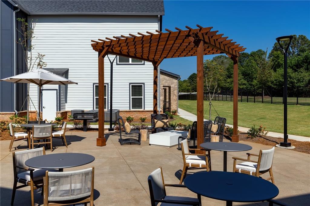 3890 Floyd Road Southwest, Unit THB1 Austell, GA 30106 - Photo 6 of 40 a view of a patio with couches table and chairs under an umbrella