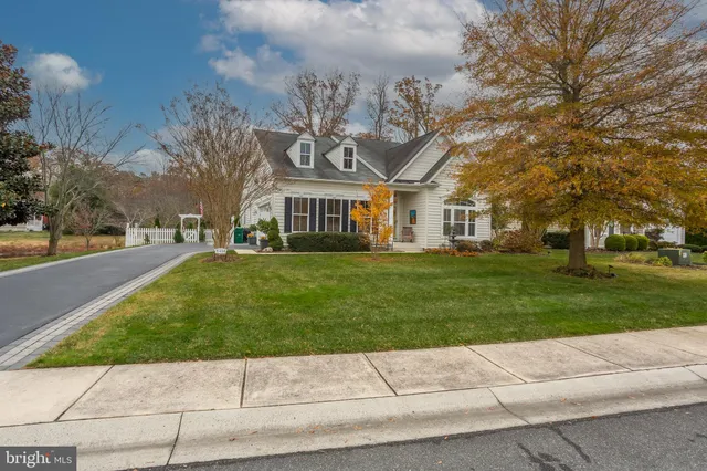 a front view of a house with a garden and trees