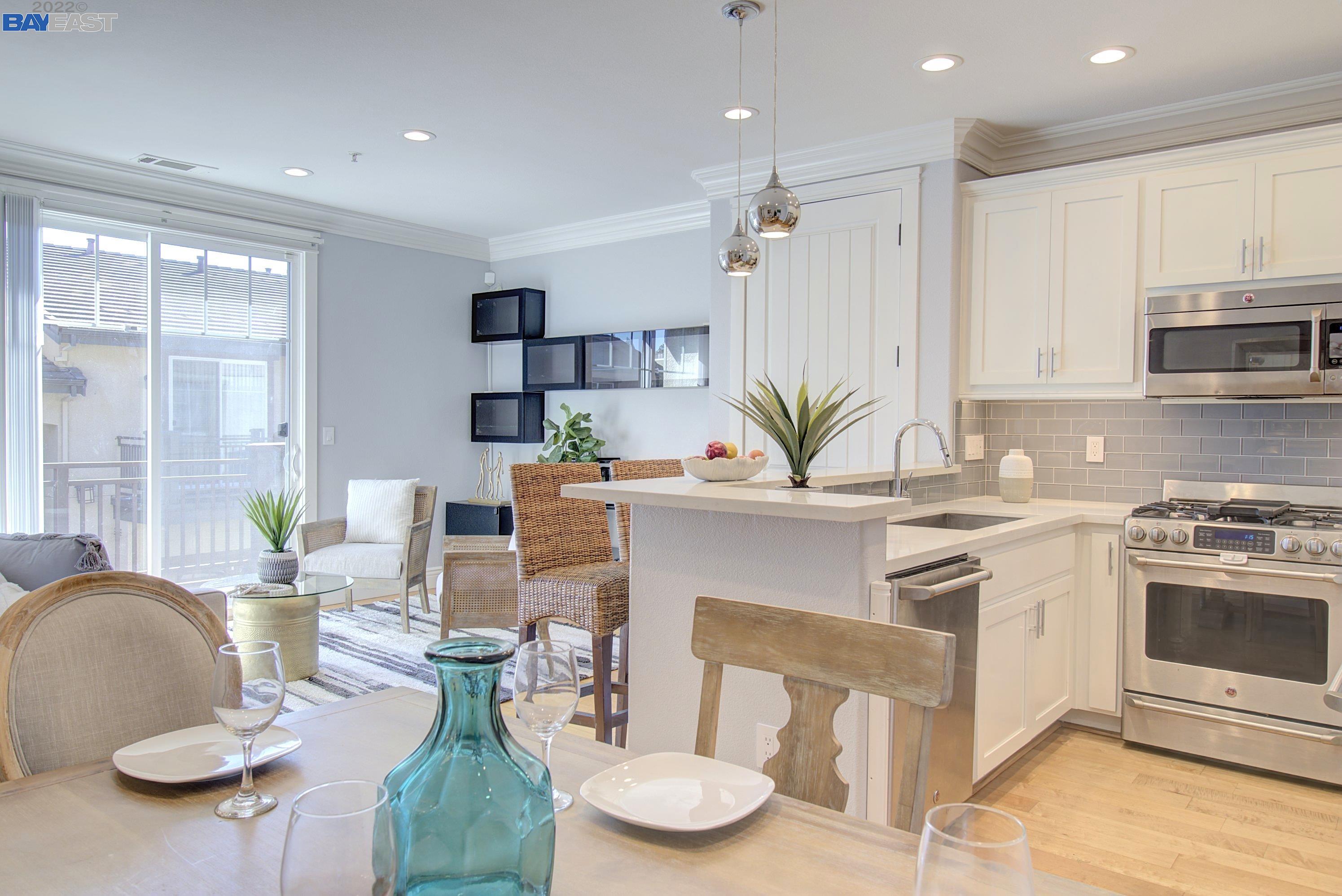 a kitchen with stainless steel appliances kitchen island granite countertop a stove a white table and chairs
