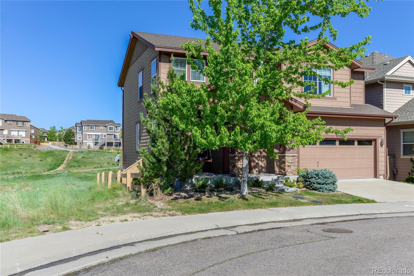 10926 Towerbridge Road Highlands Ranch, CO 80130 - Photo 34 of 34 a front view of a house with a yard and a garage
