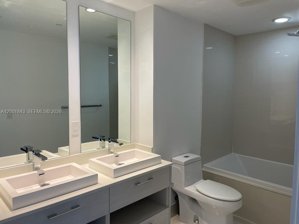 55 Southwest 9th Street, Unit 3102 Miami, FL 33130 - Photo 5 of 13 a bathroom with a sink a toilet and shower